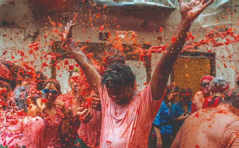 На изображении, люди бросают друг в друга помидоры, Фестиваль в Испании 